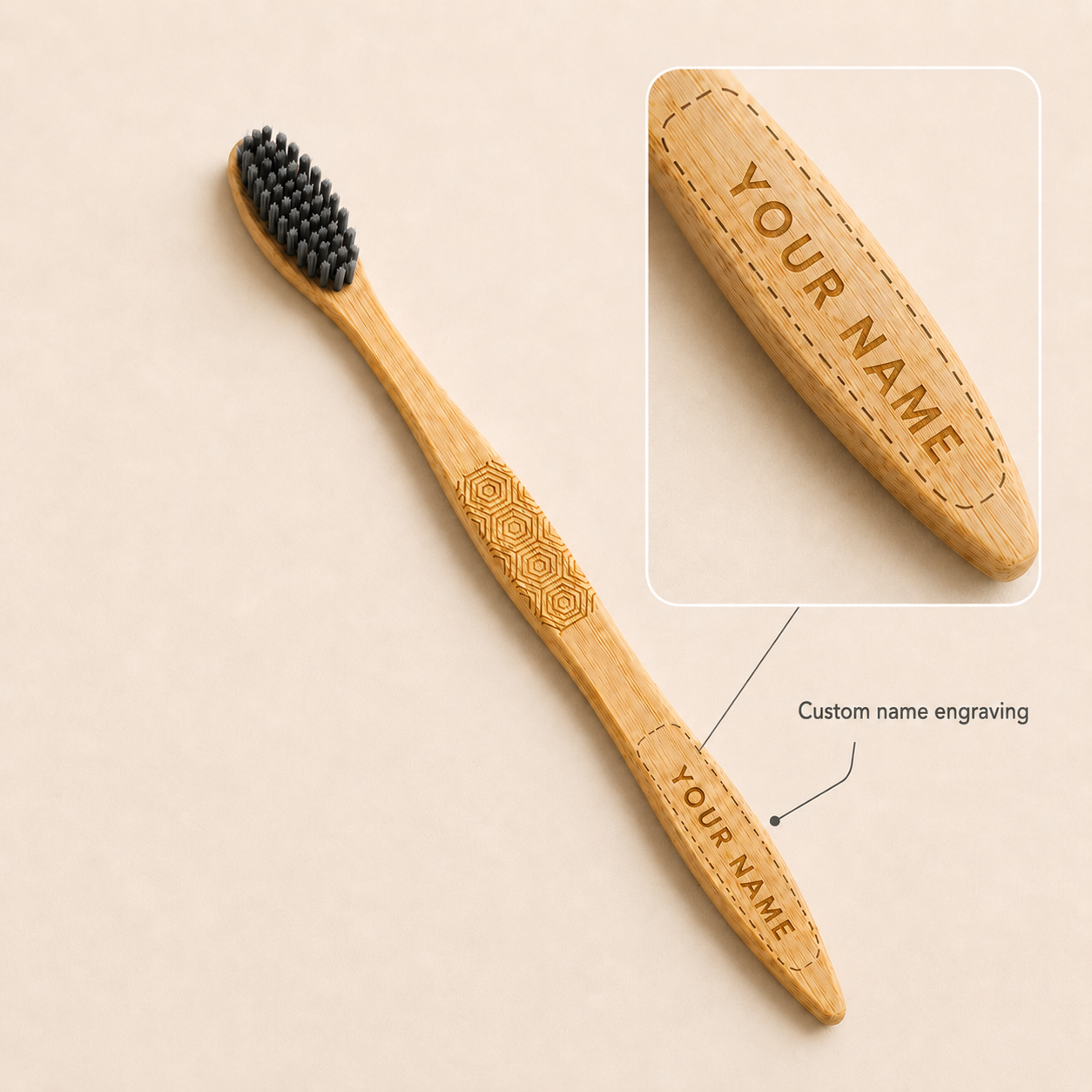 Charcoal-bristle bamboo toothbrush with a close-up preview of custom name engraving on the handle